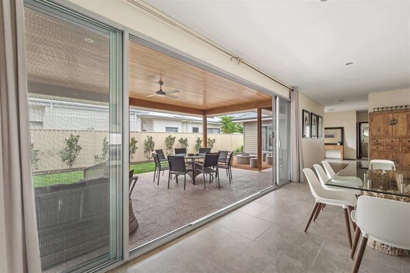 A modern interior with a glass sliding door leading to an outdoor patio area.