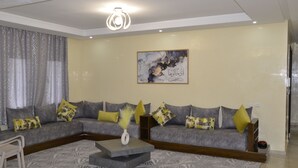 A modern living room with a grey sectional sofa, a coffee table, and a decorative vase.