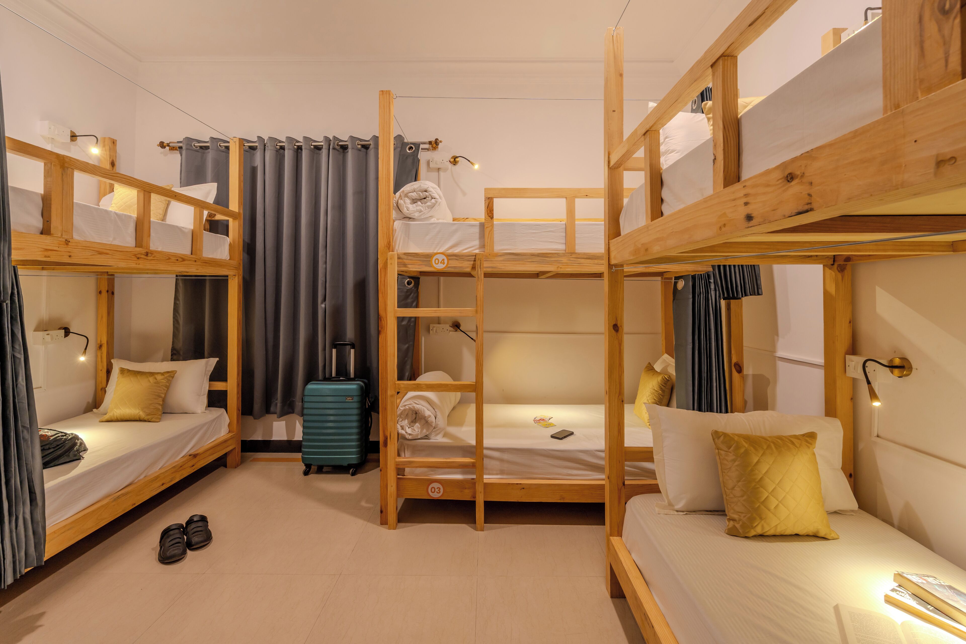 A bunk bed room with a suitcase, a lamp, and a pair of shoes on the floor.