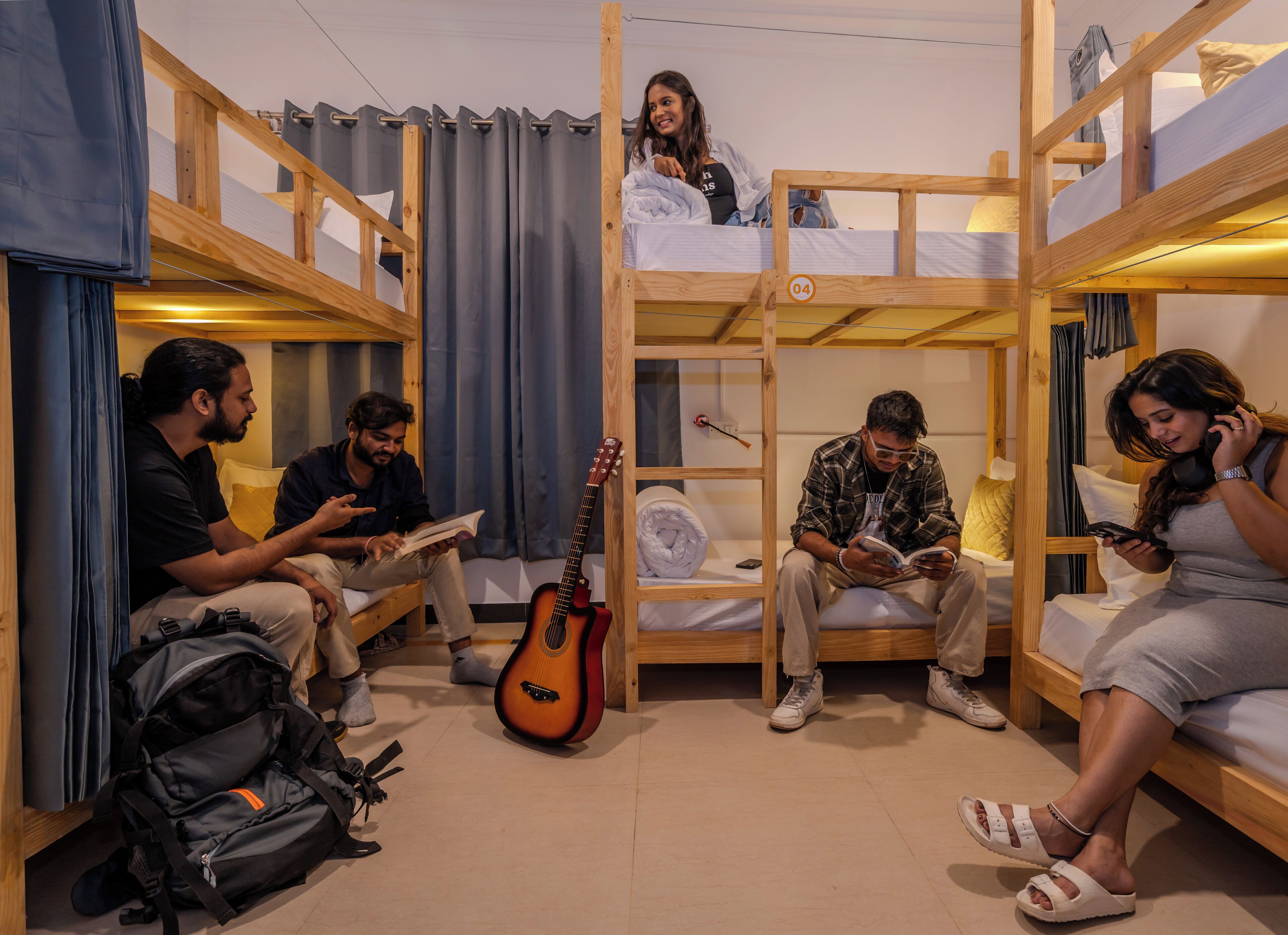 Un dormitorio con literas, una guitarra y una mochila.
