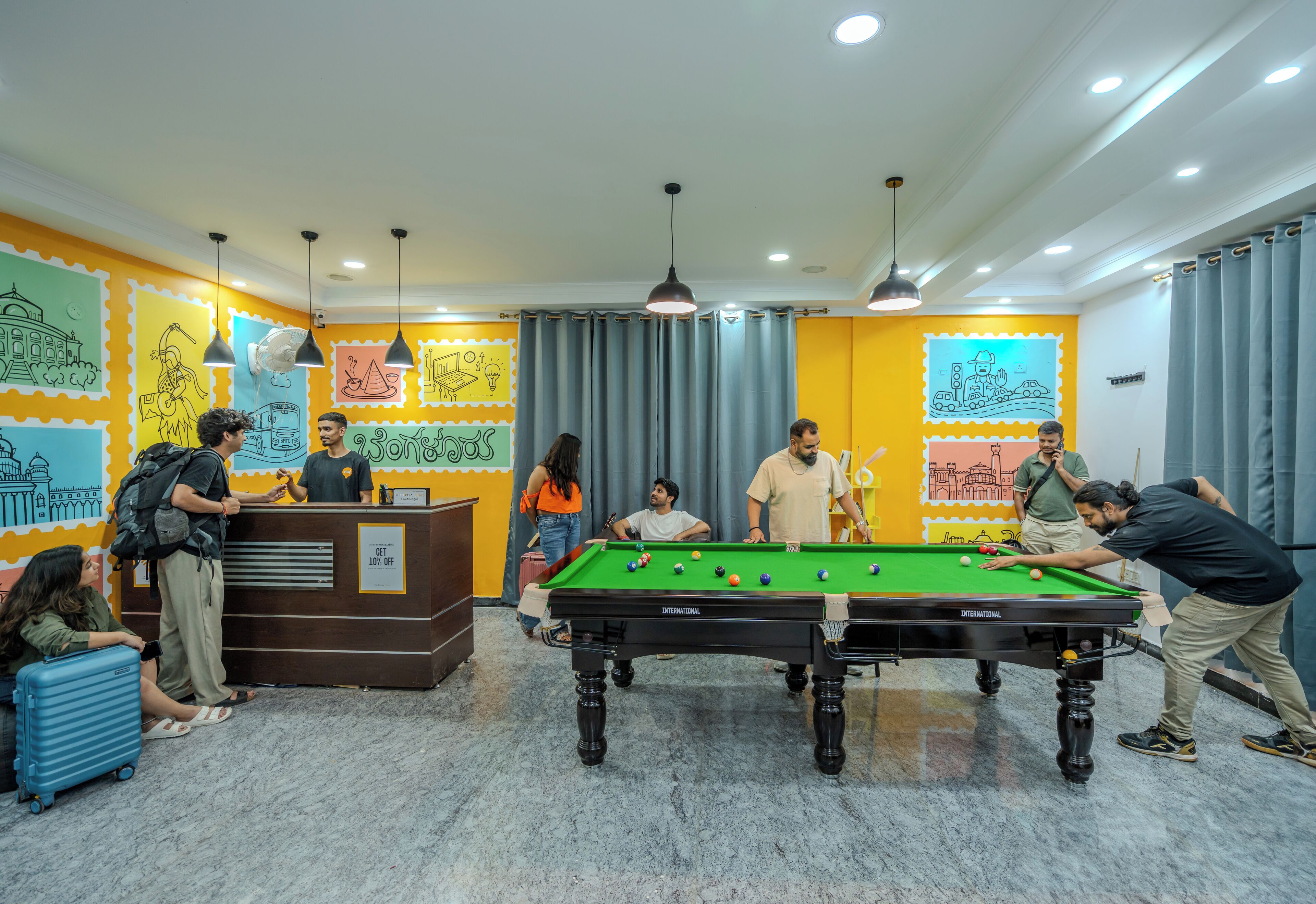 A pool table in a brightly colored room with murals on the walls.