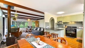 A modern kitchen with a built-in oven and a dining area with a wooden table and chairs.