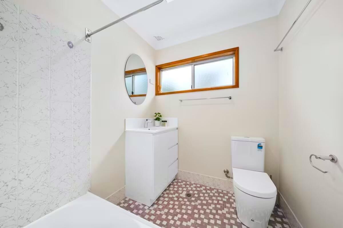 A small bathroom with a shower, toilet, and sink.