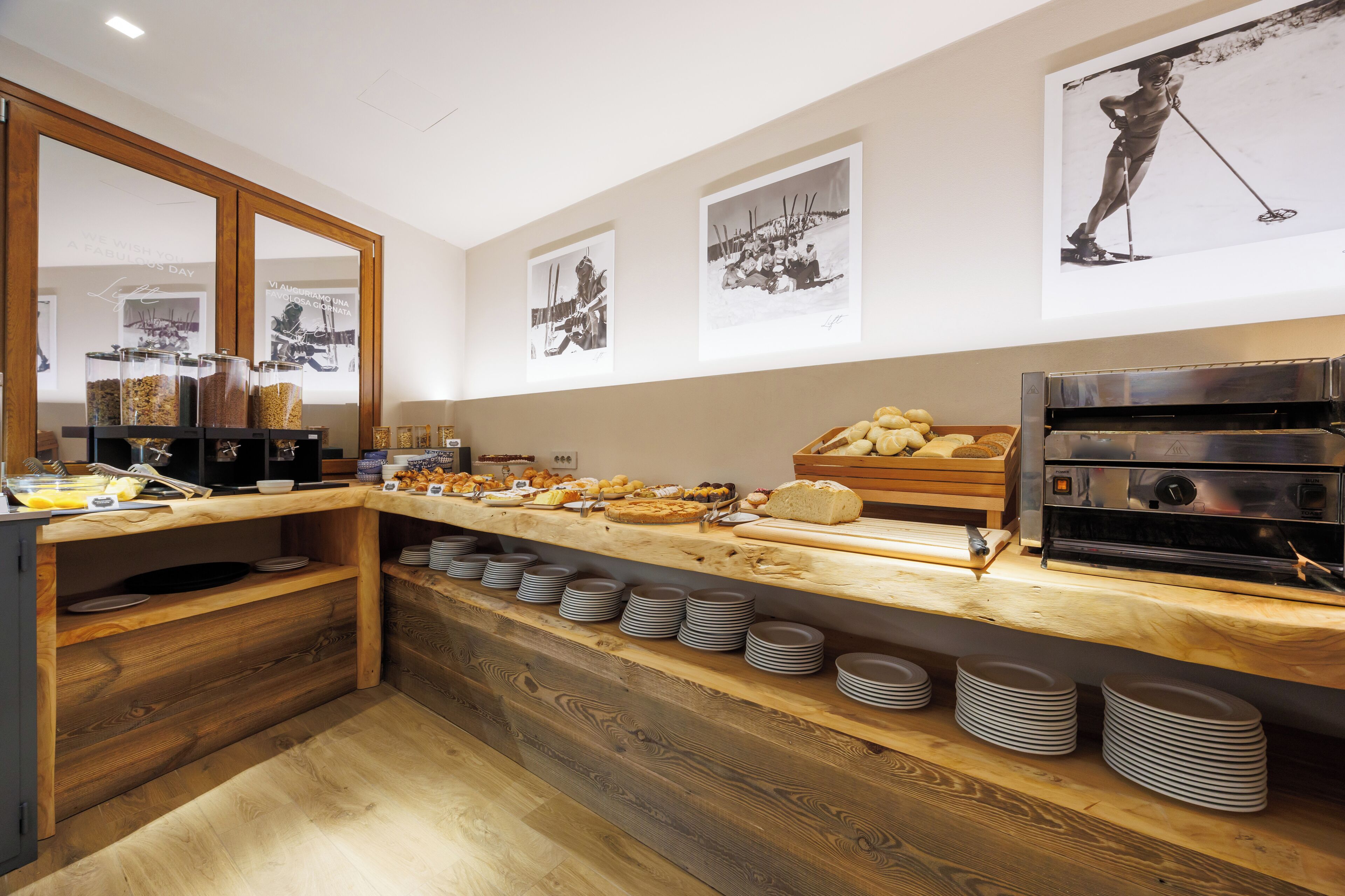 A buffet setup with various food items, a coffee machine, and a mirror reflecting the space.