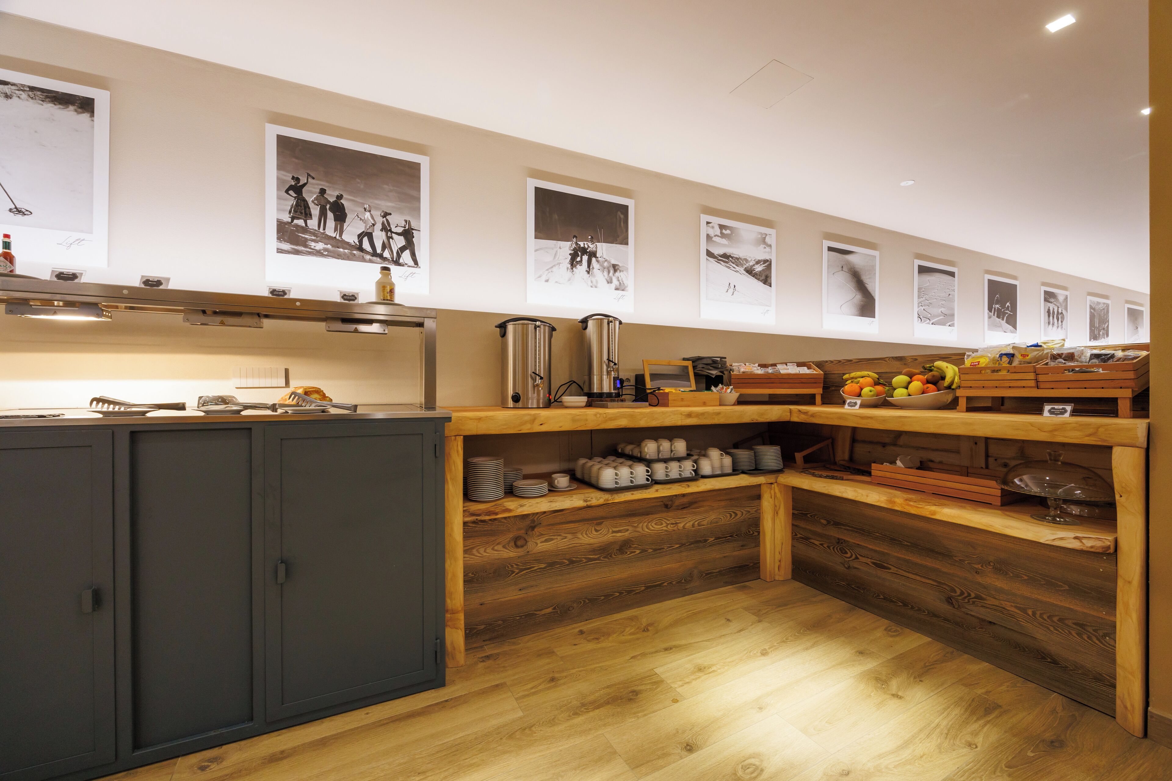 Una cocina con armarios de madera, horno empotrado y encimera de madera con diversos utensilios de cocina.