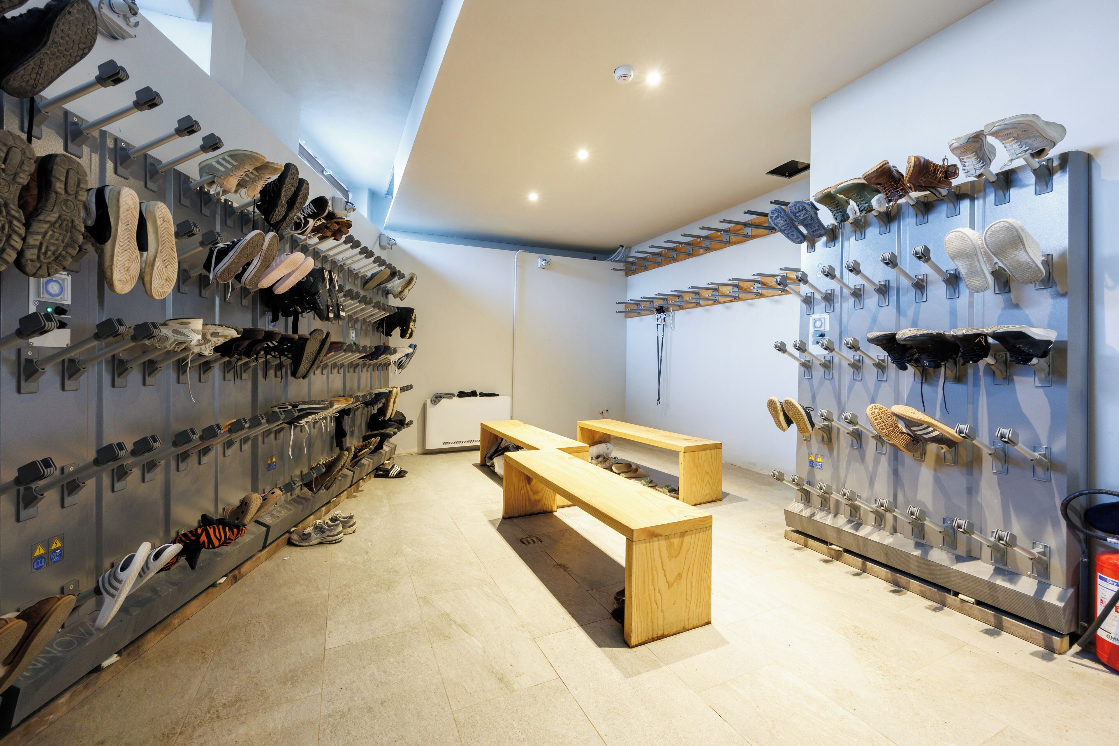 A shoe display room with multiple shoe racks and benches.