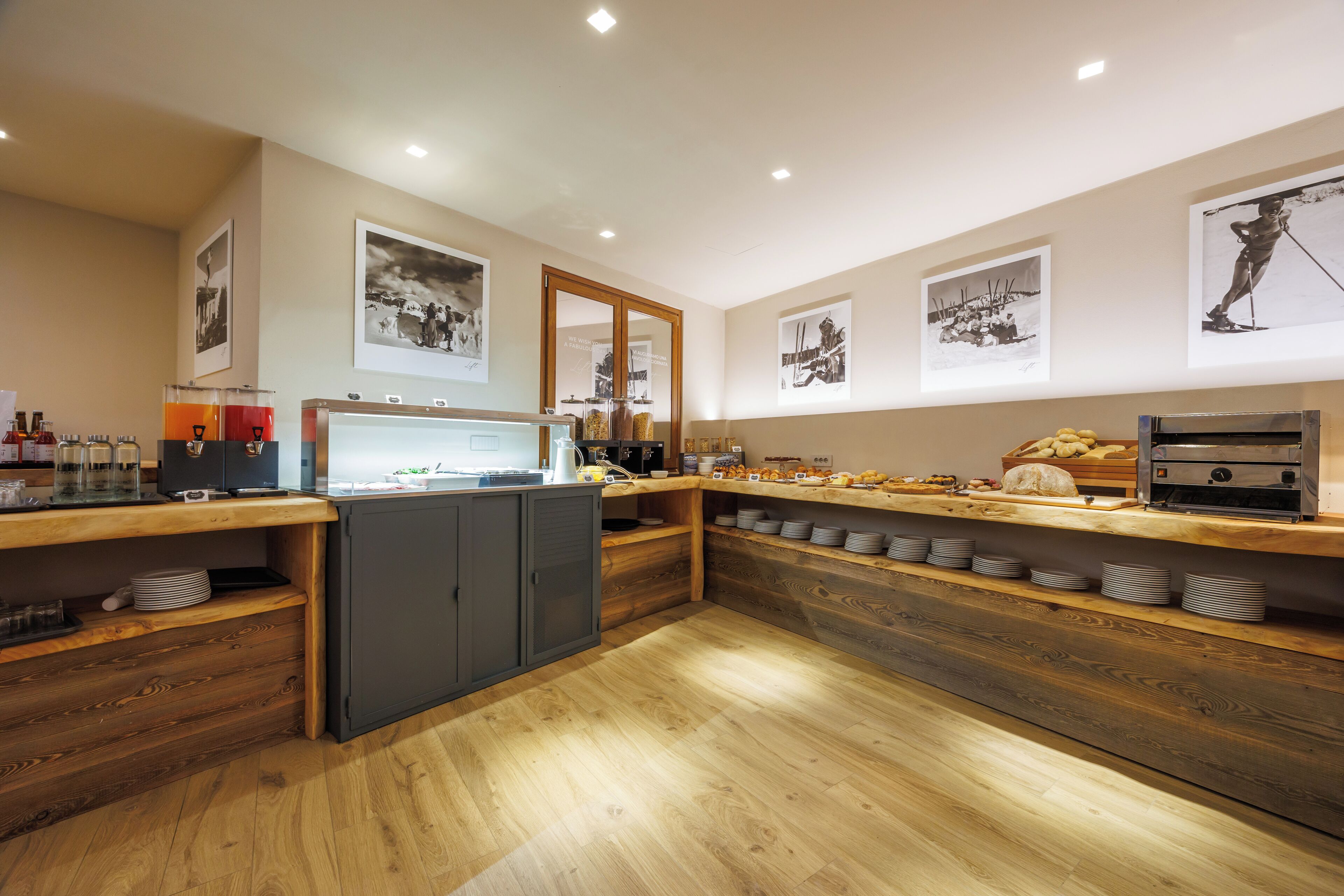 A modern kitchen with wooden countertops, a coffee station, and a display of baked goods.