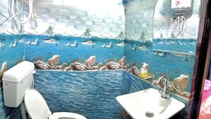 A bathroom with a marine-themed mural, a toilet, and a sink. - SANDEEP HOME STAY (Chakrata)