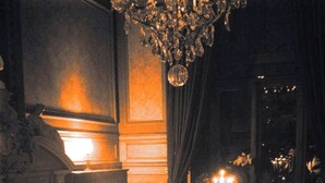 A formal dining room with a long table set for a meal, candles, and a chandelier. - Double room Delay garden view (Bruxelles)