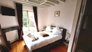 A bedroom with a bed, a TV, and a window with curtains. - Double room Delay garden view (Bruxelles)