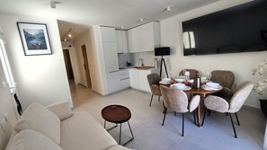 A modern apartment with a dining area, kitchen, and living room.