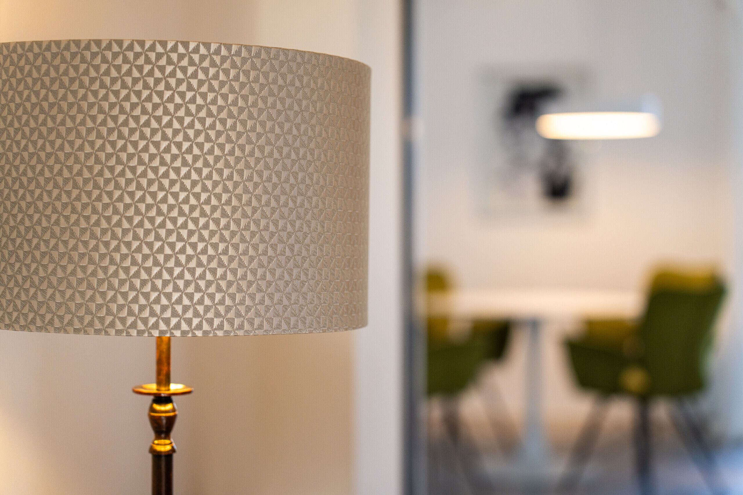 Une lampe dotée d’un abat-jour texturé et d’un pied en bois.