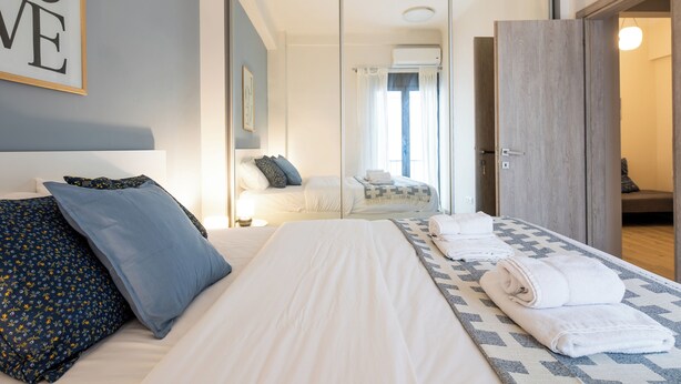 A hotel room with a large bed, a mirror, a wardrobe, and a view of another room. - The Beatles 2-BR Apartment in Athens (Athens)