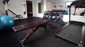 A gym with exercise equipment, a bench, a treadmill, and a mirror. - The Beatles 2-BR Apartment in Athens (Athens)