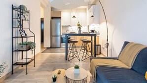 A modern living room with a sofa, a coffee table, and a bookshelf with plants. - The Beatles 2-BR Apartment in Athens (Athens)