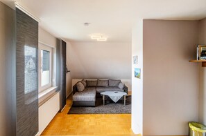 A modern living room with a sectional sofa, a small table, and a radiator.