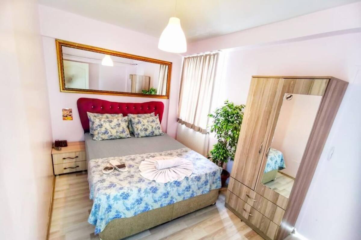 Ein Schlafzimmer mit Bett, Nachttisch, Spiegel und Kleiderschrank.