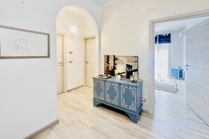 A hallway with a blue cabinet, a framed artwork, and a door leading to another room. - Le Conchiglie Di Grace - Apartment With Balcony (Alassio)