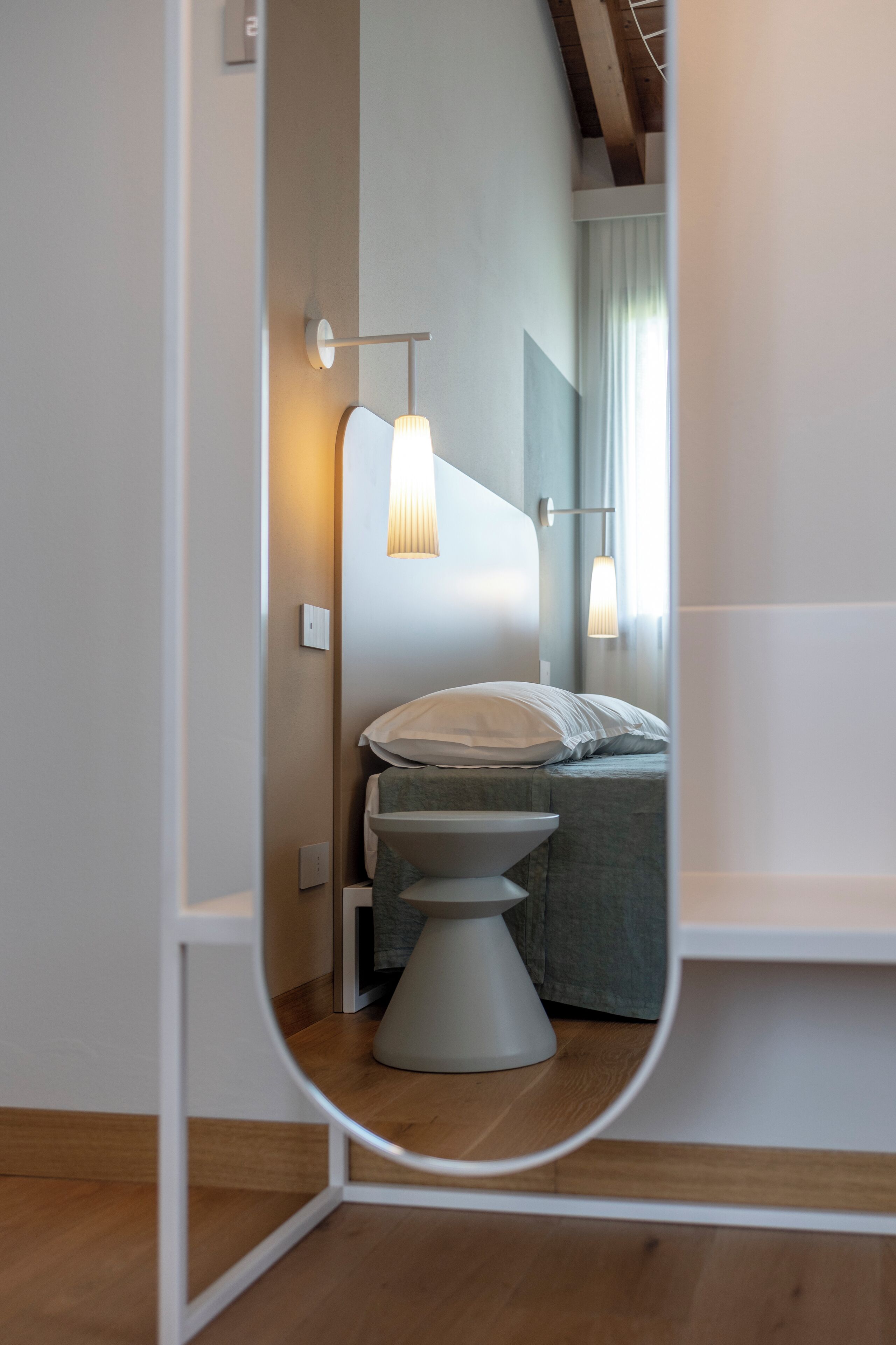 Un baño moderno con inodoro, una mesita de noche y una lámpara colgante.