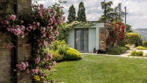 Una casa moderna con facciata in mattoni, un piccolo giardino e un vialetto che conduce all'ingresso.