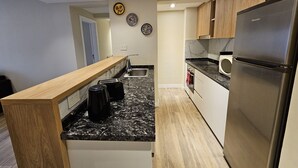 Una cocina moderna con encimera de madera, electrodomésticos de acero inoxidable y salpicadero de mármol.