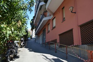 Una calle estrecha con motocicletas estacionadas y un edificio con balcones y rejas.