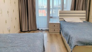 Une chambre avec deux lits, une table de chevet et une fenêtre avec des rideaux.
