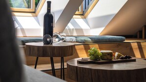 Ein modernes Loft mit Dachfenstern, einer Weinflasche und einem Käsebrett.