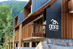 A modern building with a wooden balcony and a sign for 'Gora Resort'. - Gora Luxury Apartment (Kranjska Gora)
