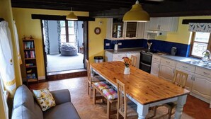 Un salon chaleureux avec une table à manger en bois, un canapé et une bibliothèque.