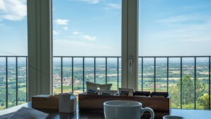 A balcony with a table set for two, a cup, and a box of coffee packets. - Locanda Moderna Carlambroeus (Montevecchia)