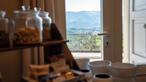 A kitchen with jars of spices and a view of mountains through a window. - Locanda Moderna Carlambroeus (Montevecchia)