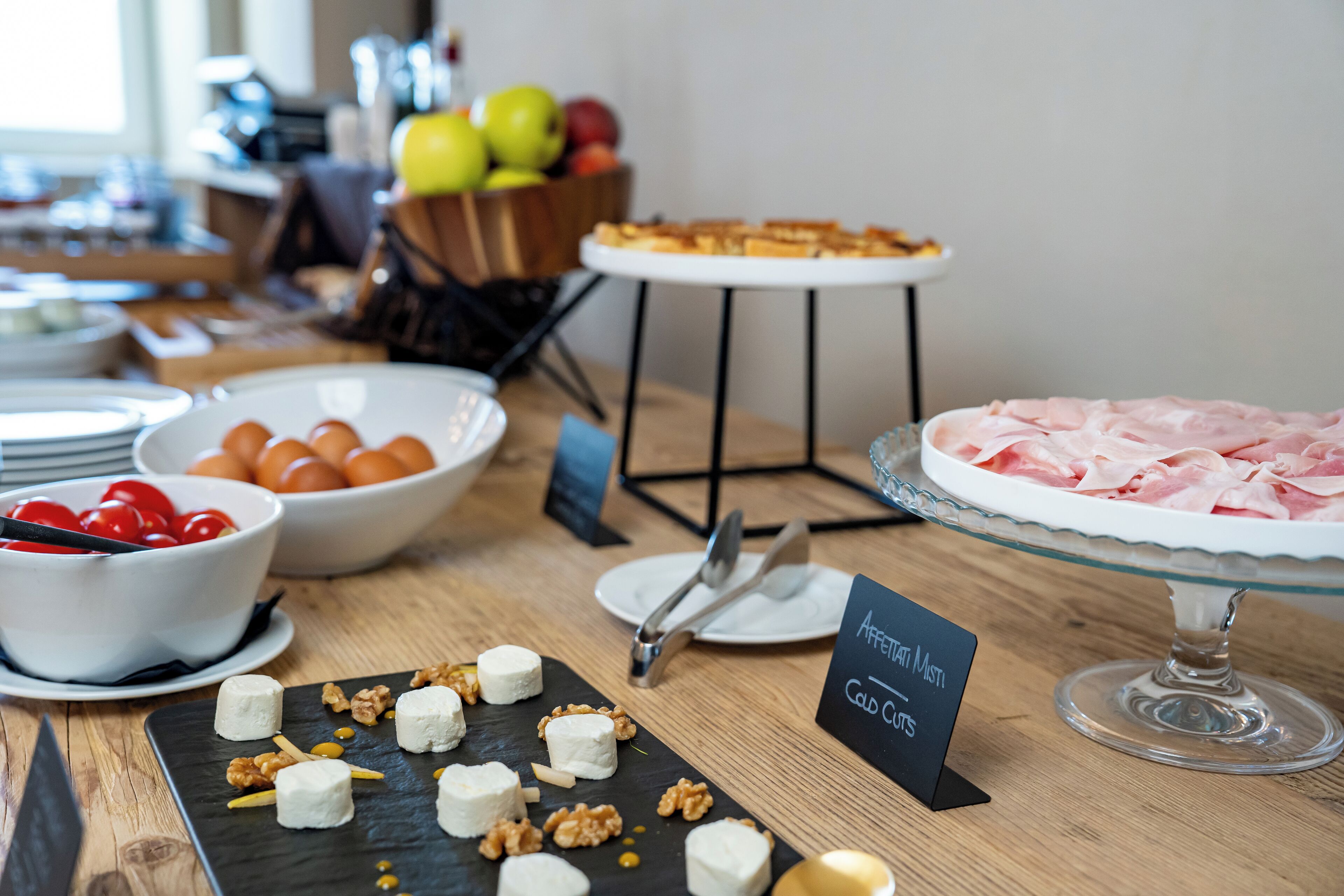 Una mesa de buffet con diferentes opciones de comida, como queso, frutos secos y frutas.