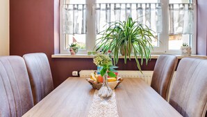 A dining table with a vase of flowers, a fruit basket, and a potted plant. - Apartment Theo in the 'Alte Schule' Holiday Home with Mountain View, Shared Terrace & Wi-Fi (Ferna)