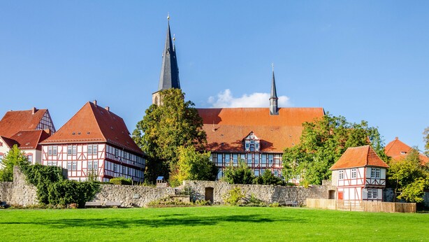 A traditional half-timbered building with a prominent church steeple, surrounded by a stone wall and lush green lawn. - Apartment Theo in the 'Alte Schule' Holiday Home with Mountain View, Shared Terrace & Wi-Fi (Ferna)