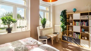 A room with a bed, a chair, a table, a bookshelf, and potted plants. - Apartment Theo in the 'Alte Schule' Holiday Home with Mountain View, Shared Terrace & Wi-Fi (Ferna)