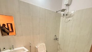 Ein kleines, sauberes Badezimmer mit Toilette, Waschbecken und Dusche.
