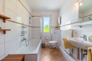 Une salle de bain moderne avec une baignoire, des toilettes et un lavabo.