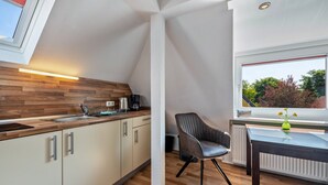 Eine moderne Küche mit Holzarbeitsplatten, einer eingebauten Spüle und einem Fenster mit Blick auf Bäume.
