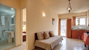 A room with a bed, a bathroom, and a kitchen area. - Semeli Stalis (Stalida)