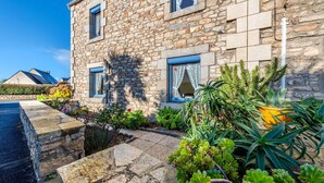 A stone building with a garden in front, featuring a stone pathway, various plants, and a small pond. - Holiday Home 'Maison De Caractère' with Wi-Fi (Roscoff)