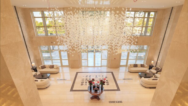 A spacious lobby with a central coffee table, sofas, and a decorative ceiling installation. - Helnan Antoniades Palace (Alexandria)