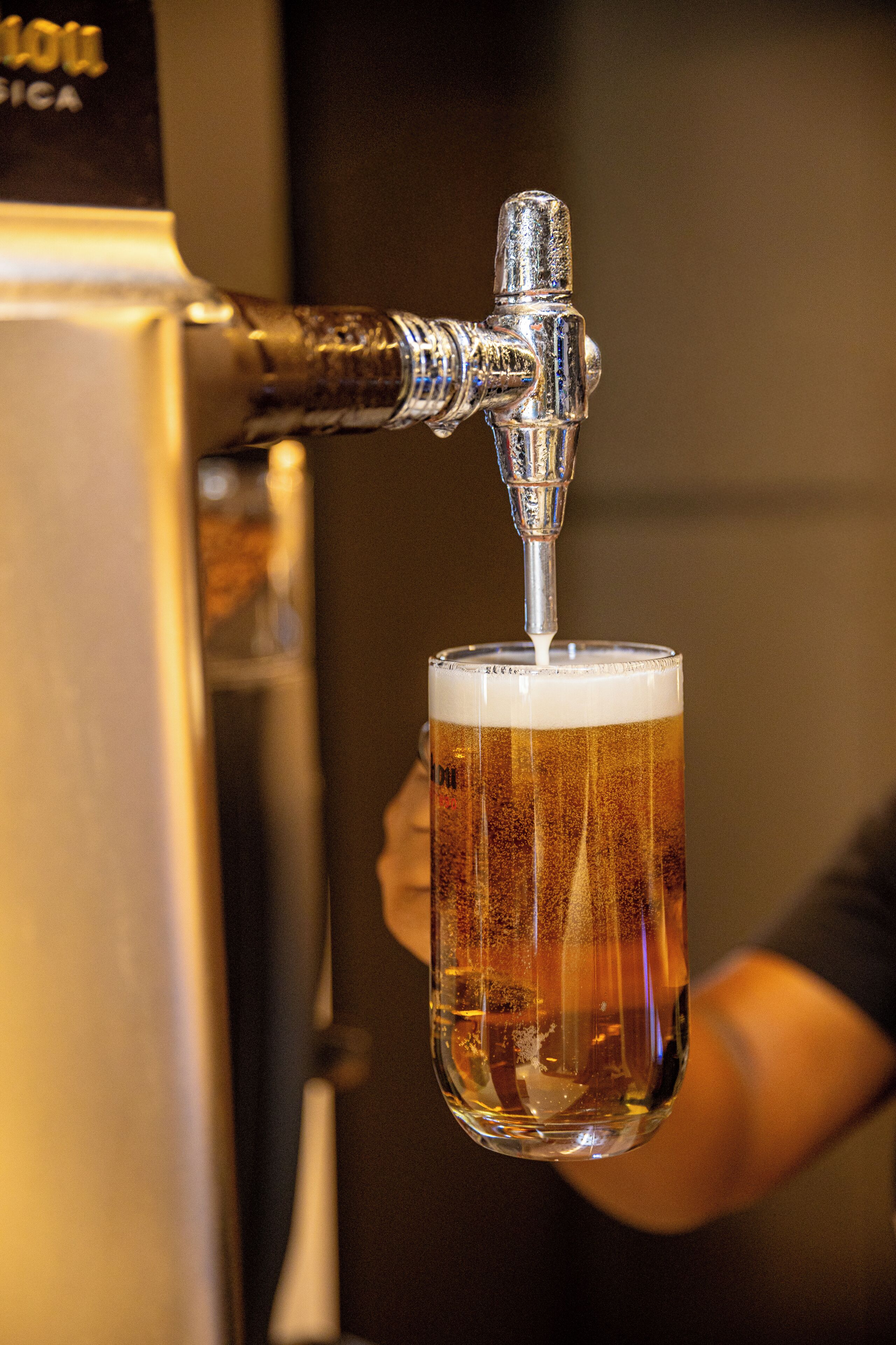 A tap pouring beer into a glass.