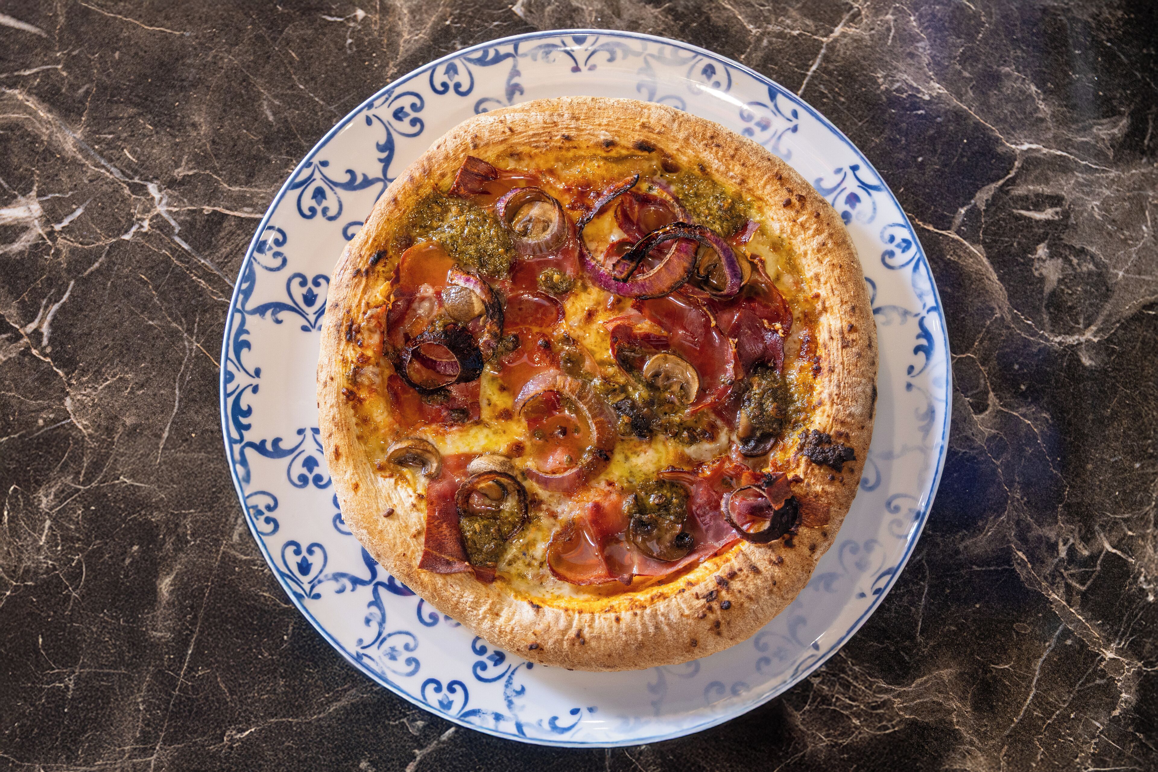Una pizza sobre un plato decorativo.