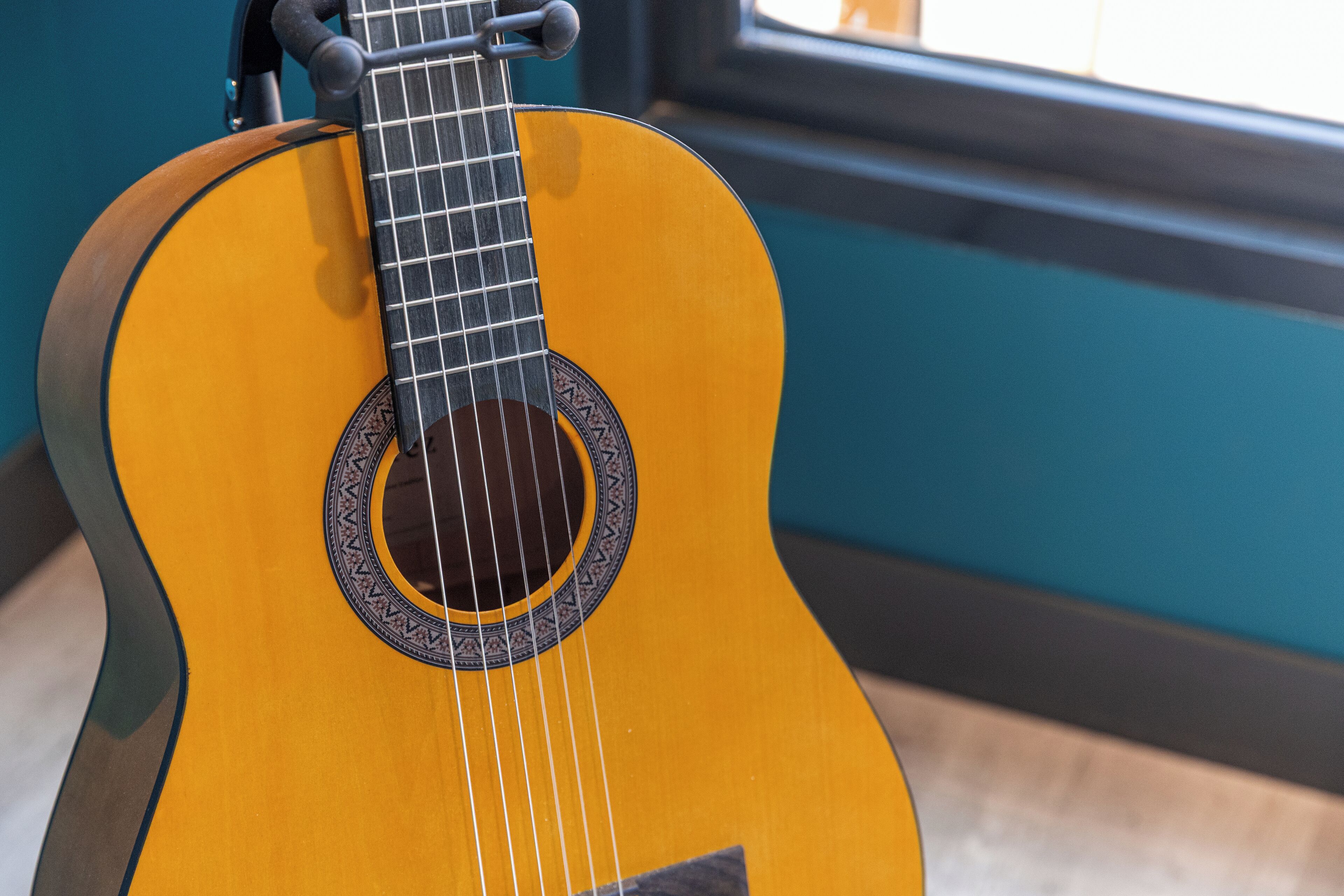 A close-up of a guitar with a circular sound hole and a decorative rosette.