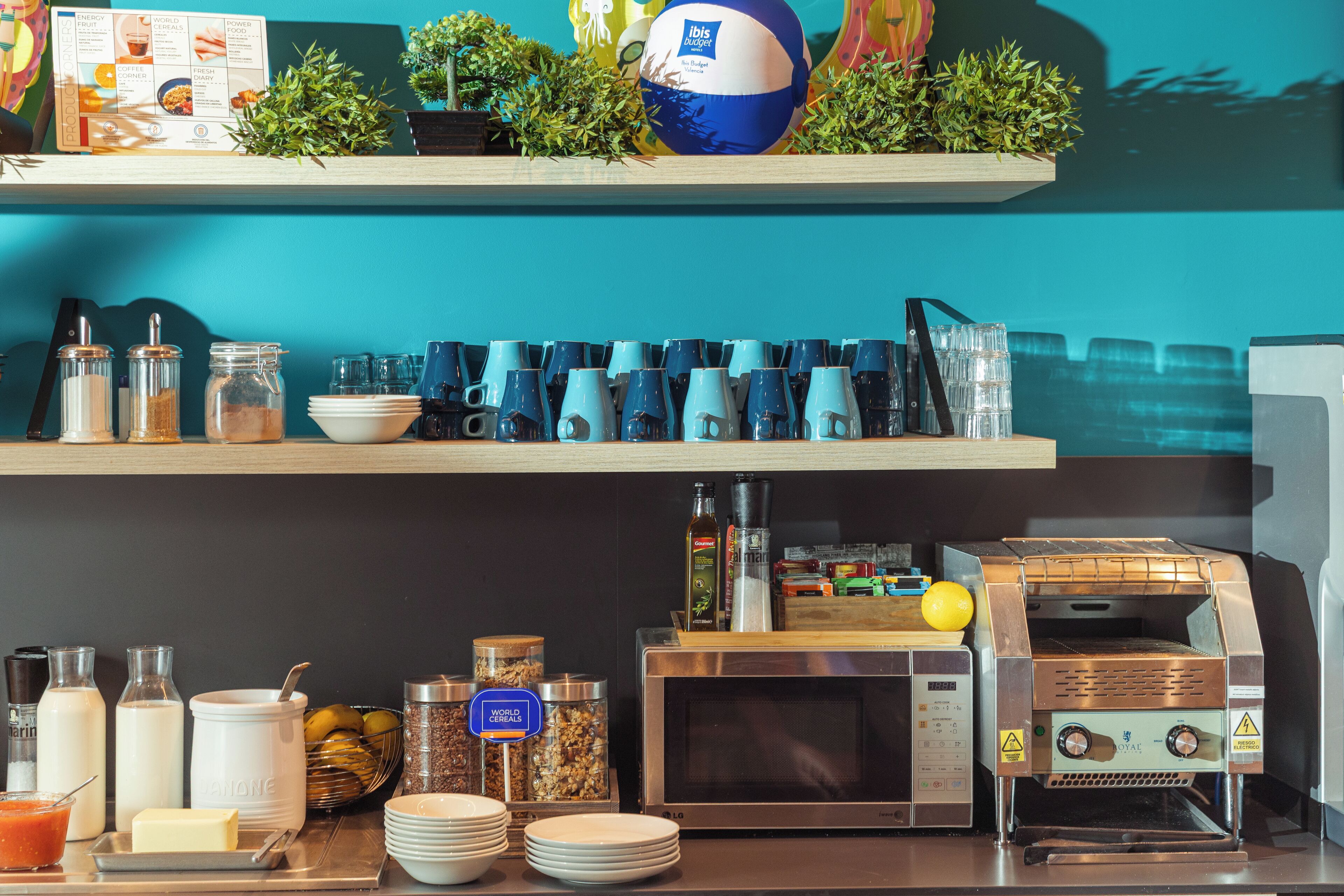 Una barra de desayuno con diferentes opciones de comida, un microondas y una máquina de café.