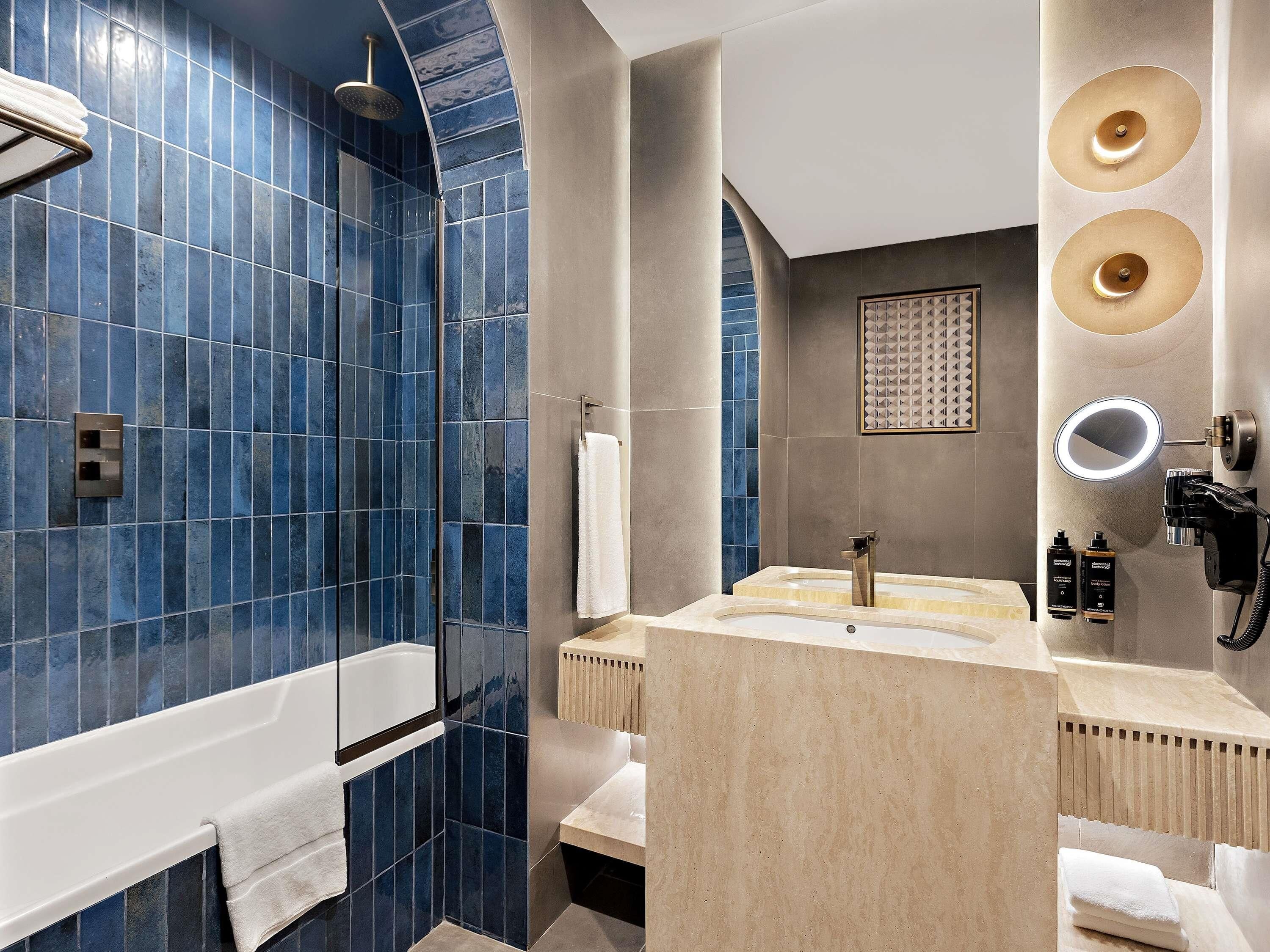 Une salle de bain moderne avec une baignoire, un meuble-lavabo avec un miroir et un espace douche.
