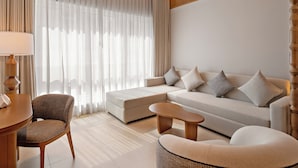 Una sala de estar moderna con un sofá, sillones, una mesa de centro y una lámpara.