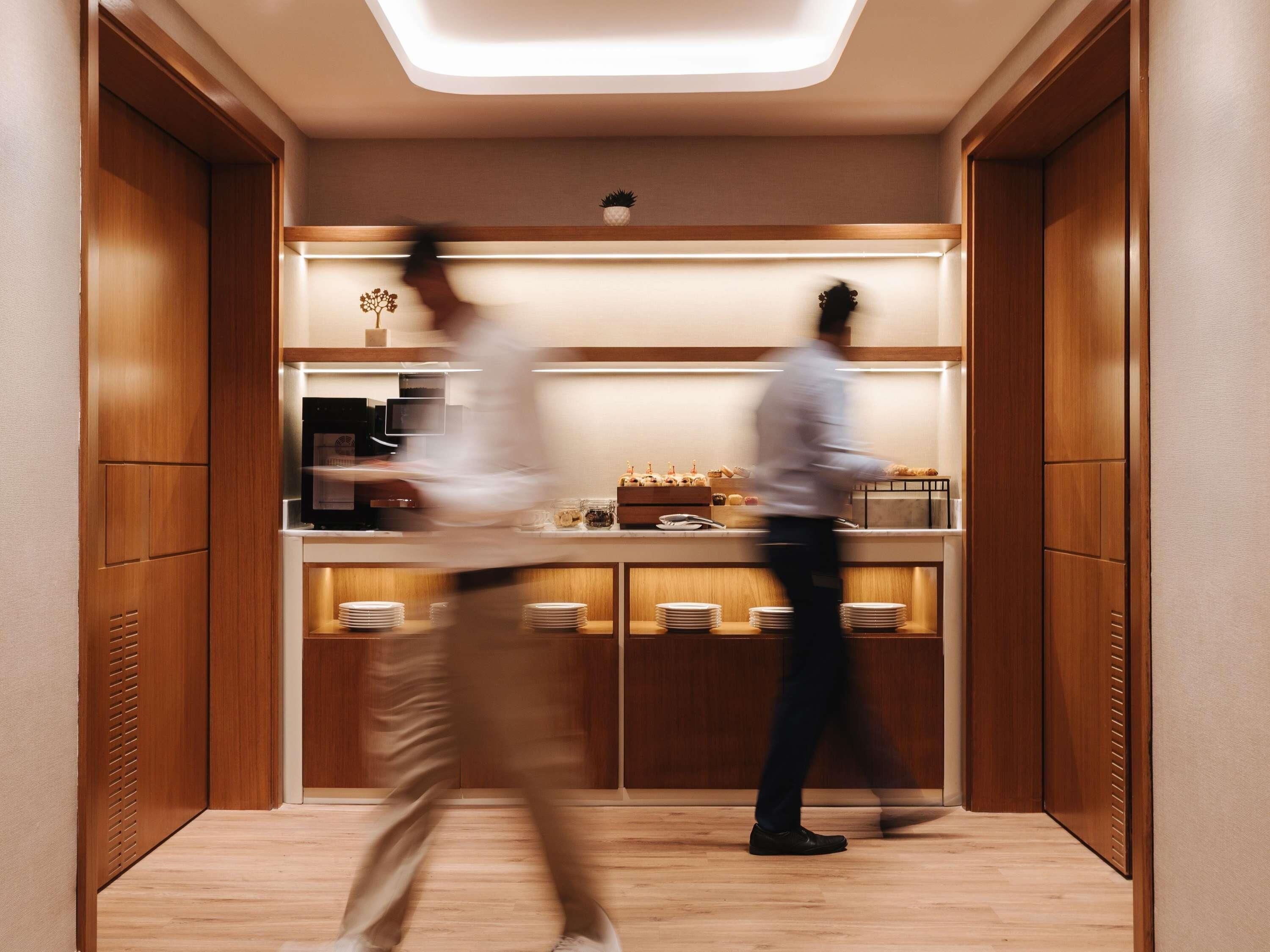 Un ascenseur moderne avec des panneaux en bois et un luminaire lumineux placé en haut.
