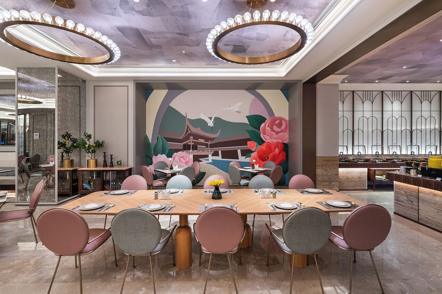 A dining area with a long table, multiple chairs, and a decorative mural in the background.